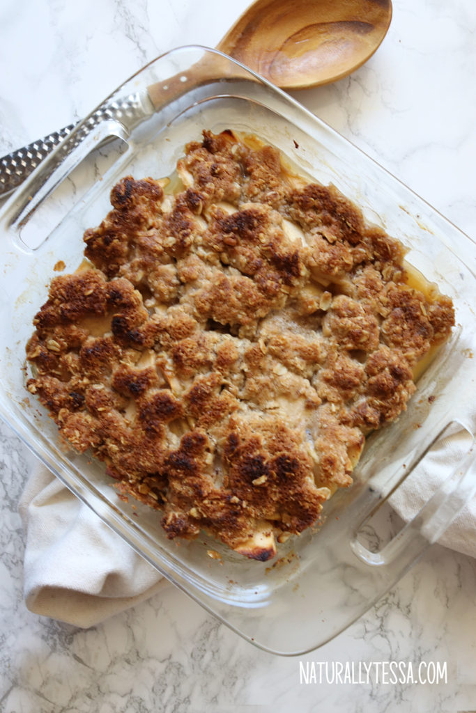 Baked apple crisp ready to serve on top of a white quartz table